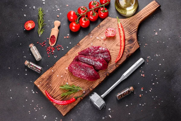 新鲜的生牛肉牛排米农 胡椒玉米 百里香 西红柿 生鲜的大理石肉 牛排和深色背景的调味品 — 图库照片
