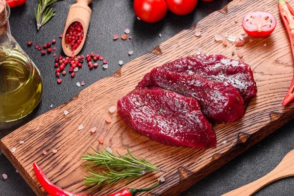 新鮮な生牛のステーキミニョン コショウ タイム トマト 新鮮な霜降り肉のステーキと調味料を暗い背景に — ストック写真