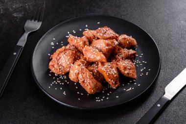 Susamlı tavuk fileto, siyah taş tabakta teriyaki sosu. Asya mutfağı