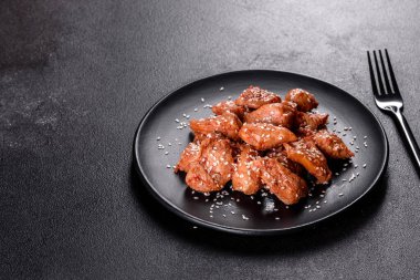 Susamlı tavuk fileto, siyah taş tabakta teriyaki sosu. Asya mutfağı
