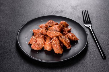 Susamlı tavuk fileto, siyah taş tabakta teriyaki sosu. Asya mutfağı