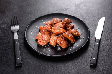Susamlı tavuk fileto, siyah taş tabakta teriyaki sosu. Asya mutfağı