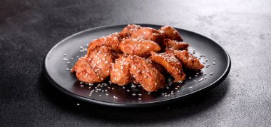 Susamlı tavuk fileto, siyah taş tabakta teriyaki sosu. Asya mutfağı