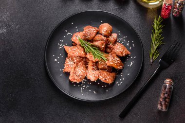 Susamlı tavuk fileto, siyah taş tabakta teriyaki sosu. Asya mutfağı