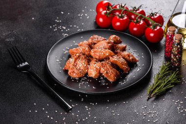 Susamlı tavuk fileto, siyah taş tabakta teriyaki sosu. Asya mutfağı