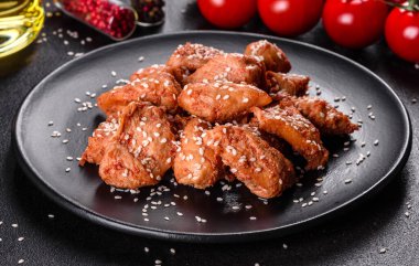 Susamlı tavuk fileto, siyah taş tabakta teriyaki sosu. Asya mutfağı