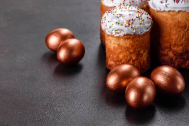 Paskalya yumurtası, altın, bronz ve arka planda Paskalya pastası. Tatil için hazırlık