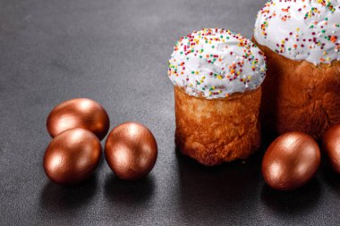 Paskalya yumurtası, altın, bronz ve arka planda Paskalya pastası. Tatil için hazırlık