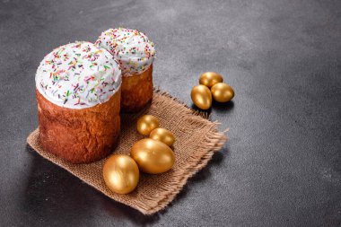 Paskalya yumurtası, altın, bronz ve arka planda Paskalya pastası. Tatil için hazırlık