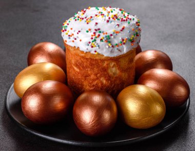 Paskalya yumurtası, altın, bronz ve arka planda Paskalya pastası. Tatil için hazırlık