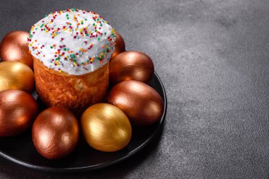 Paskalya yumurtası, altın, bronz ve arka planda Paskalya pastası. Tatil için hazırlık