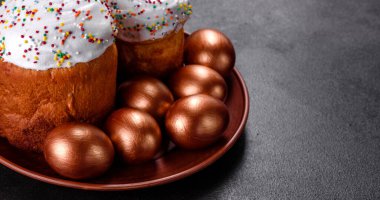 Paskalya yumurtası, altın, bronz ve arka planda Paskalya pastası. Tatil için hazırlık