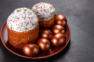 Paskalya yumurtası, altın, bronz ve arka planda Paskalya pastası. Tatil için hazırlık