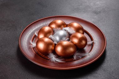 Paskalya yumurtası, altın, bronz ve arka planda Paskalya pastası. Tatil için hazırlık