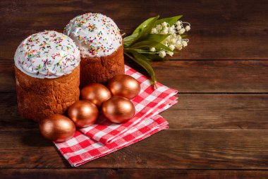 Paskalya yumurtası, altın, bronz ve arka planda Paskalya pastası. Tatil için hazırlık