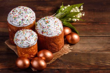 Paskalya yumurtası, altın, bronz ve arka planda Paskalya pastası. Tatil için hazırlık