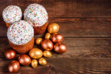Paskalya yumurtası, altın, bronz ve arka planda Paskalya pastası. Tatil için hazırlık