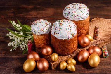Paskalya yumurtası, altın, bronz ve arka planda Paskalya pastası. Tatil için hazırlık