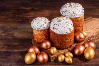 Paskalya yumurtası, altın, bronz ve arka planda Paskalya pastası. Tatil için hazırlık