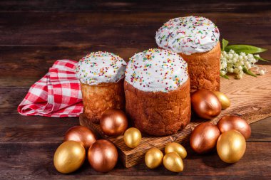 Paskalya yumurtası, altın, bronz ve arka planda Paskalya pastası. Tatil için hazırlık