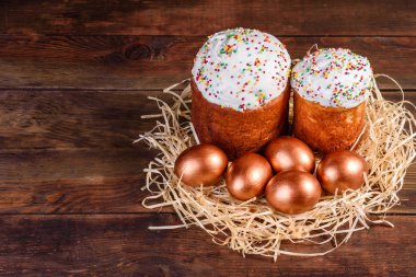 Yuvadaki Paskalya altın yumurtaları, bayram hazırlıkları. Koyu renkli arka planda yuvadaki altın yumurtalar.
