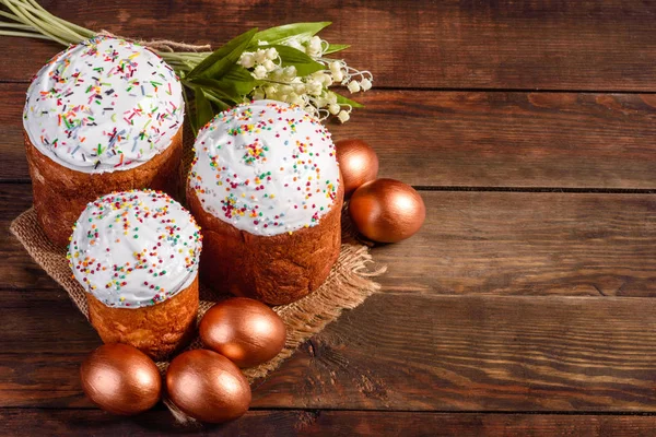 Easter eggs gold and bronze and Easter cake on a dark background. Preparation for the holiday