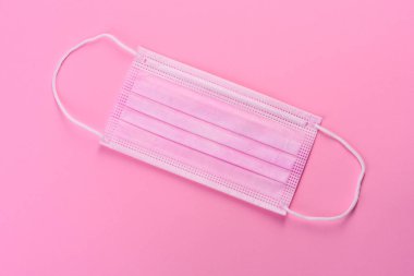 Renkli bir arka planda tıbbi maske, koronovirüs ve salgına karşı bir koruma aracı. Dünya çapında salgın, koruma