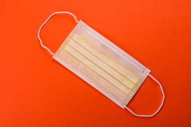 Renkli bir arka planda tıbbi maske, koronovirüs ve salgına karşı bir koruma aracı. Dünya çapında salgın, koruma