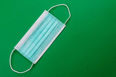 Renkli bir arka planda tıbbi maske, koronovirüs ve salgına karşı bir koruma aracı. Dünya çapında salgın, koruma