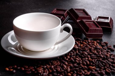 Aromatik sabah kahvesi hazırlığı. Koyu bir masada boş beyaz kahve fincanı.