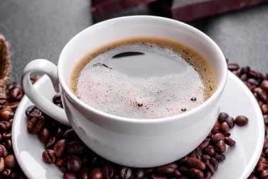 Güne neşeyle başlamak için bir fincan taze kokulu sabah kahvesi. Koyu kahve masasında güzel bir kahve fincanı.