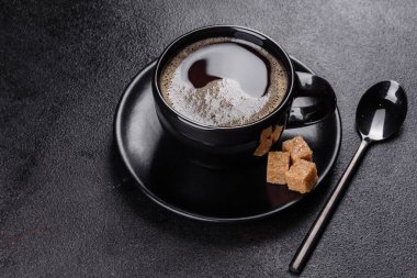 Güne neşeyle başlamak için bir fincan taze kokulu sabah kahvesi. Koyu kahve masasında güzel bir kahve fincanı.