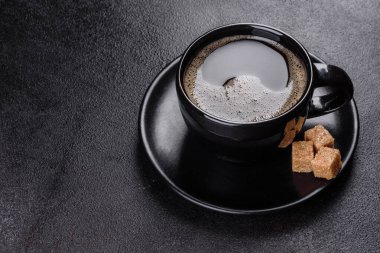 Güne neşeyle başlamak için bir fincan taze kokulu sabah kahvesi. Koyu kahve masasında güzel bir kahve fincanı.