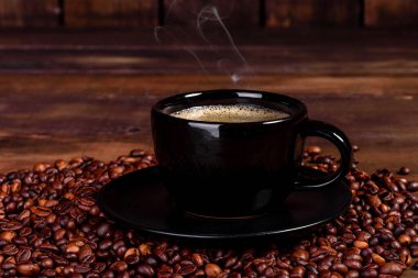 Güne neşeyle başlamak için bir fincan taze kokulu sabah kahvesi. Koyu kahve masasında güzel bir kahve fincanı.