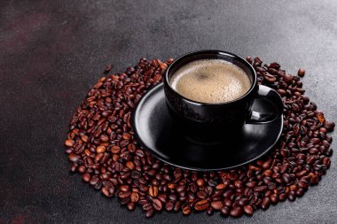 Güne neşeyle başlamak için bir fincan taze kokulu sabah kahvesi. Koyu kahve masasında güzel bir kahve fincanı.