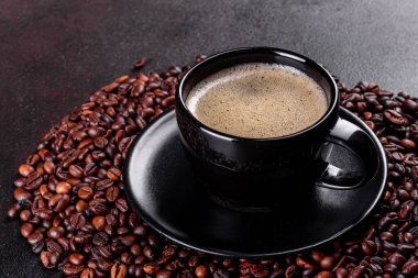 Güne neşeyle başlamak için bir fincan taze kokulu sabah kahvesi. Koyu kahve masasında güzel bir kahve fincanı.