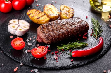 Patates, soğan ve kiraz domatesli pirzola. Lezzetli tereyağlı lezzetli biftek.