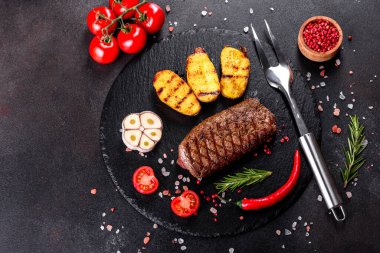 Patates, soğan ve kiraz domatesli pirzola. Lezzetli tereyağlı lezzetli biftek.