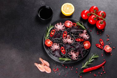 Siyah zemin üzerinde karides, ahtapot ve midye olan siyah deniz ürünleri makarnası. Akdeniz gurme yemekleri. Siyah ahtapot kaplı siyah makarna.