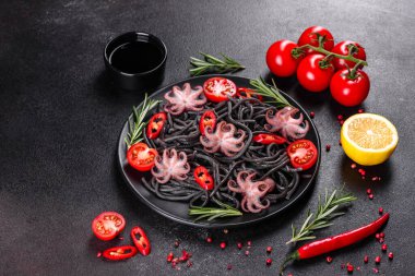 Siyah zemin üzerinde karides, ahtapot ve midye olan siyah deniz ürünleri makarnası. Akdeniz gurme yemekleri. Siyah ahtapot kaplı siyah makarna.