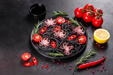 Siyah zemin üzerinde karides, ahtapot ve midye olan siyah deniz ürünleri makarnası. Akdeniz gurme yemekleri. Siyah ahtapot kaplı siyah makarna.