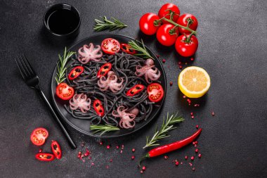 Siyah zemin üzerinde karides, ahtapot ve midye olan siyah deniz ürünleri makarnası. Akdeniz gurme yemekleri. Siyah ahtapot kaplı siyah makarna.