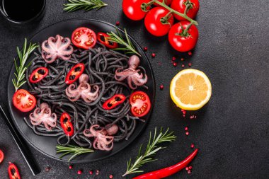 Siyah zemin üzerinde karides, ahtapot ve midye olan siyah deniz ürünleri makarnası. Akdeniz gurme yemekleri. Siyah ahtapot kaplı siyah makarna.