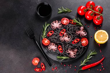 Siyah zemin üzerinde karides, ahtapot ve midye olan siyah deniz ürünleri makarnası. Akdeniz gurme yemekleri. Siyah ahtapot kaplı siyah makarna.