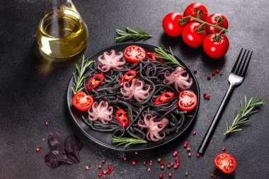 Siyah zemin üzerinde karides, ahtapot ve midye olan siyah deniz ürünleri makarnası. Akdeniz gurme yemekleri. Siyah ahtapot kaplı siyah makarna.