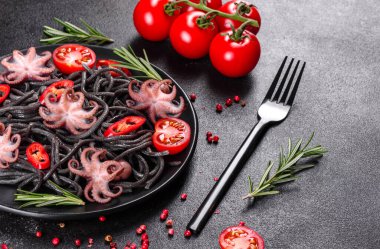 Siyah zemin üzerinde karides, ahtapot ve midye olan siyah deniz ürünleri makarnası. Akdeniz gurme yemekleri. Siyah ahtapot kaplı siyah makarna.