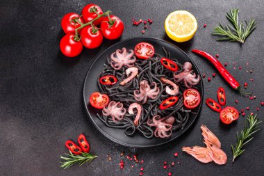 Siyah zemin üzerinde karides, ahtapot ve midye olan siyah deniz ürünleri makarnası. Akdeniz gurme yemekleri. Siyah ahtapot kaplı siyah makarna.