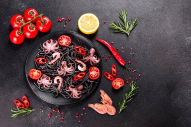 Siyah zemin üzerinde karides, ahtapot ve midye olan siyah deniz ürünleri makarnası. Akdeniz gurme yemekleri. Siyah ahtapot kaplı siyah makarna.