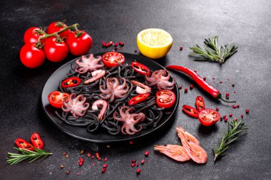 Siyah zemin üzerinde karides, ahtapot ve midye olan siyah deniz ürünleri makarnası. Akdeniz gurme yemekleri. Siyah ahtapot kaplı siyah makarna.