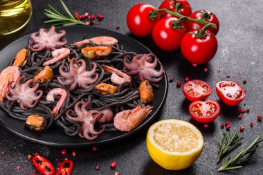 Siyah zemin üzerinde karides, ahtapot ve midye olan siyah deniz ürünleri makarnası. Akdeniz gurme yemekleri. Siyah ahtapot kaplı siyah makarna.